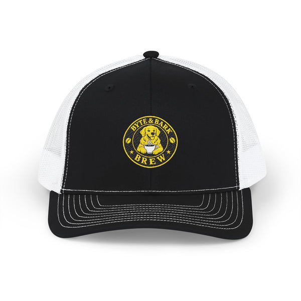 Front view of black and white trucker cap with embroidered Byte & Bark Brew® golden retriever patch