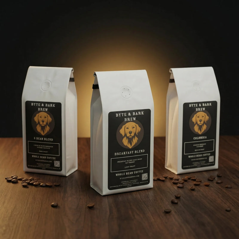 Three white coffee bags with Byte & Bark Brew® labels standing on wooden surface with scattered beans