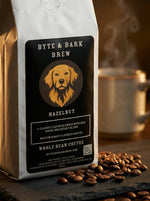 White bag of Byte & Bark Brew® Hazelnut whole bean coffee with scattered beans in foreground