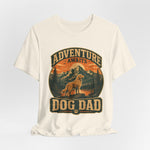 Off-white crewneck t-shirt with vintage circular mountain scene, dog silhouette, 'Adventure Awaits' and large 'DOG DAD' lettering