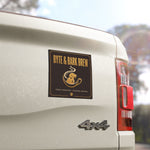 Byte & Bark Brew® rectangular black-and-gold magnet mounted on a light vehicle tailgate near taillight