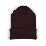 Top-down flat-lay of a folded knit beanie with visible cuff on plain white background