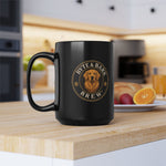 Black coffee mug with Byte & Bark Brew® gold dog logo, shown on wooden counter