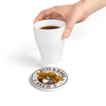 White ceramic coaster with Byte & Bark Brew® round logo showing three dogs and coffee cup