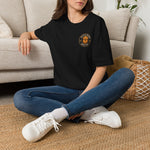 Model seated cross-legged wearing black tee with Byte & Bark Brew® golden retriever chest logo