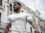 Low-angle portrait of man wearing white tee with Byte & Bark Brew® text, blurred building background