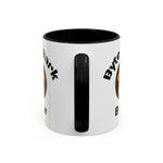 Close-up front view of white mug with black interior and handle, partial black diagonal text