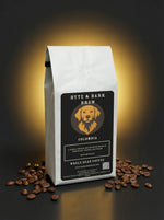 White Byte & Bark Brew® coffee bag labeled Colombia with dog logo, beans scattered below