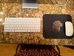 Top-down desk view showing white keyboard and black mouse pad with stylized dog illustration