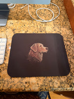 Black rectangular mouse pad with copper-toned stylized dog and circuit pattern, on granite