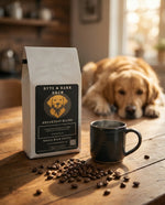 White Byte & Bark Brew® Breakfast Blend bag beside steaming black mug, coffee beans and blurred golden retriever