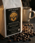 White Byte & Bark Brew® coffee bag with golden dog logo, beans scattered and steaming mug