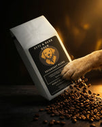 Tilted white coffee bag labeled Byte & Bark Brew® Breakfast Blend with dog paw and falling beans