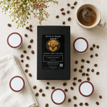 Byte & Bark Brew® black coffee box with dog logo, surrounded by pods, scattered beans, and steaming mug