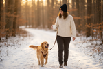 Black knit beanie with embroidered circular patch worn by model walking dog in snowy trail
